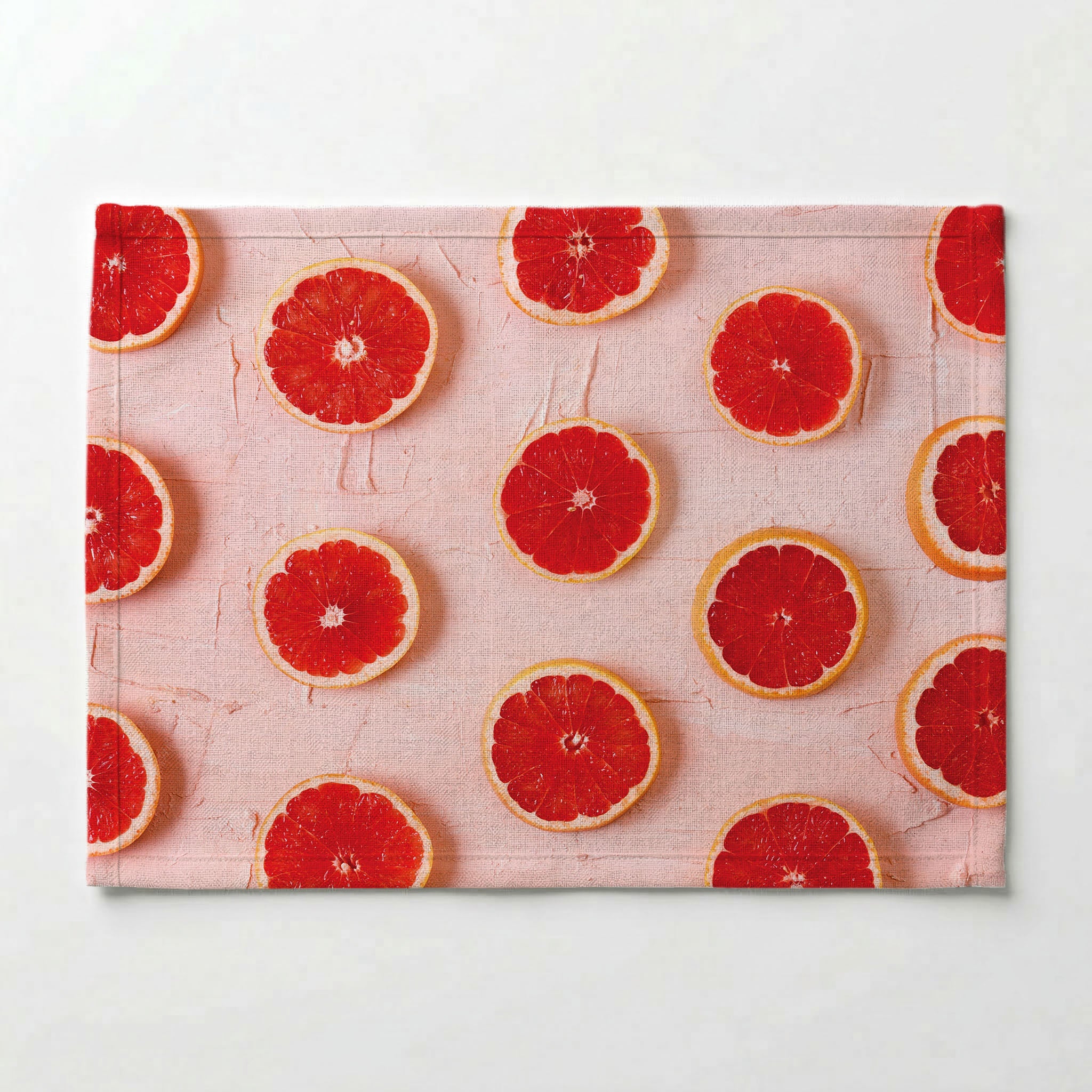 GRAPEFRUIT SLICES ON PINK PLACEMAT