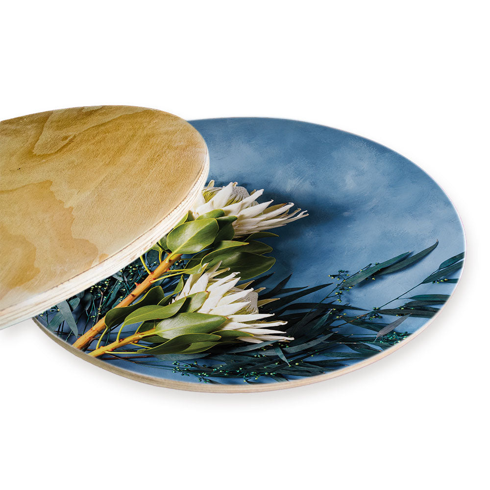 WHITE PROTEAS AND EUCALYPTUS ON BLUE CHEESEBOARD