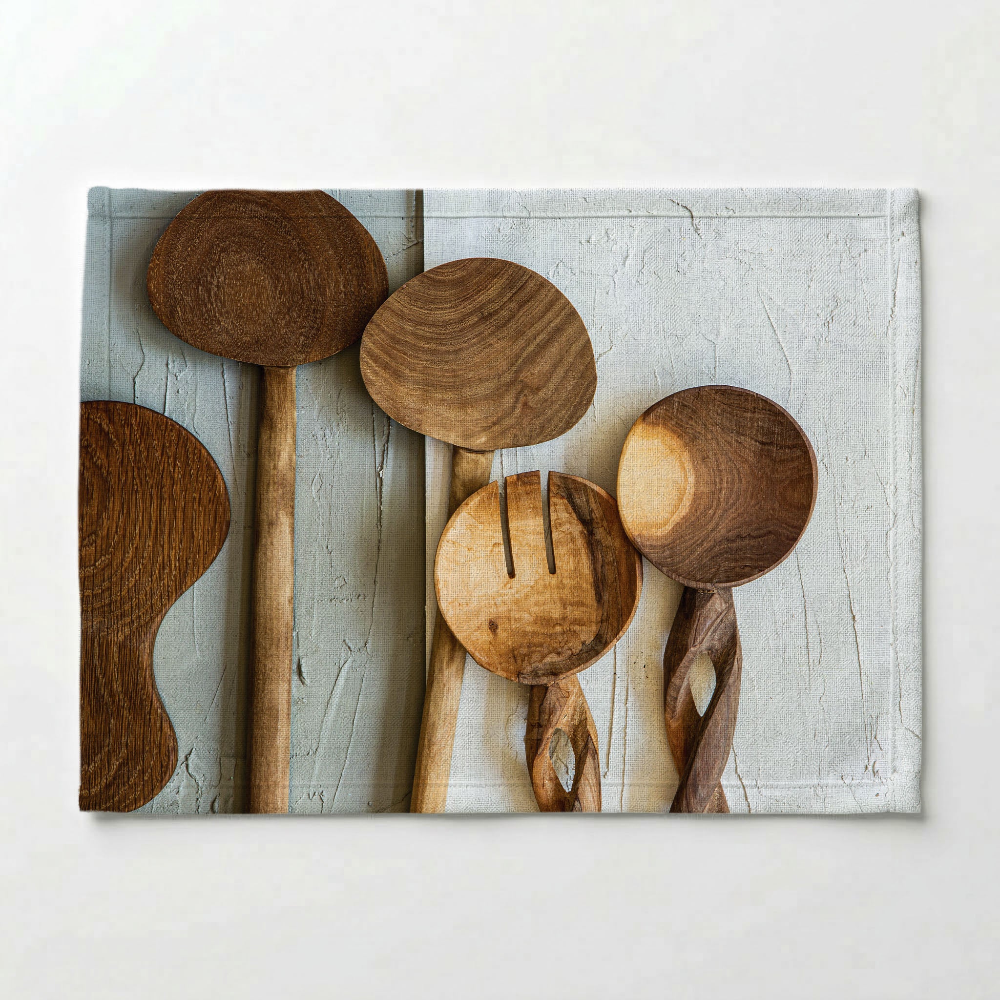 NATURAL BROWN WOODEN SPOONS ON GREY AND WHITE PLACEMAT